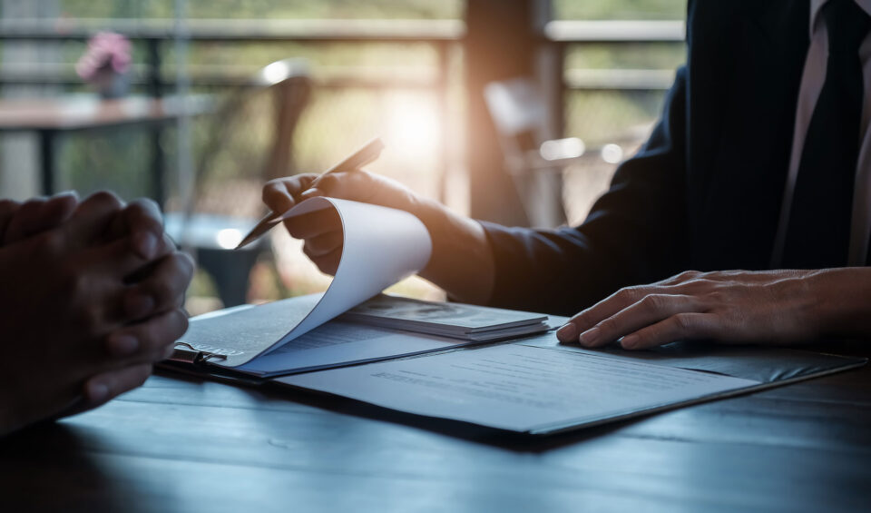 Närbild på händer som bläddrar bland papper