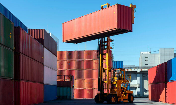 En truck lyfter upp en container på ett containerupplag.