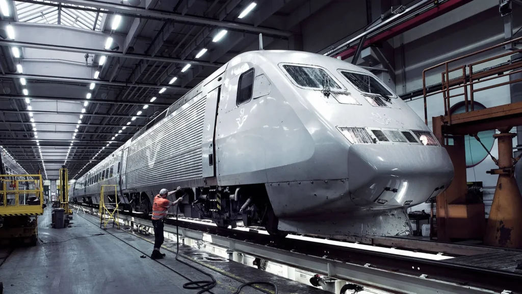 Ett tåg blir servat i en tågdepå.