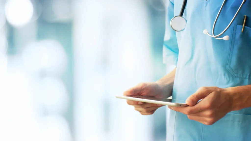 Sjukhuspersonal håller i en ipad.