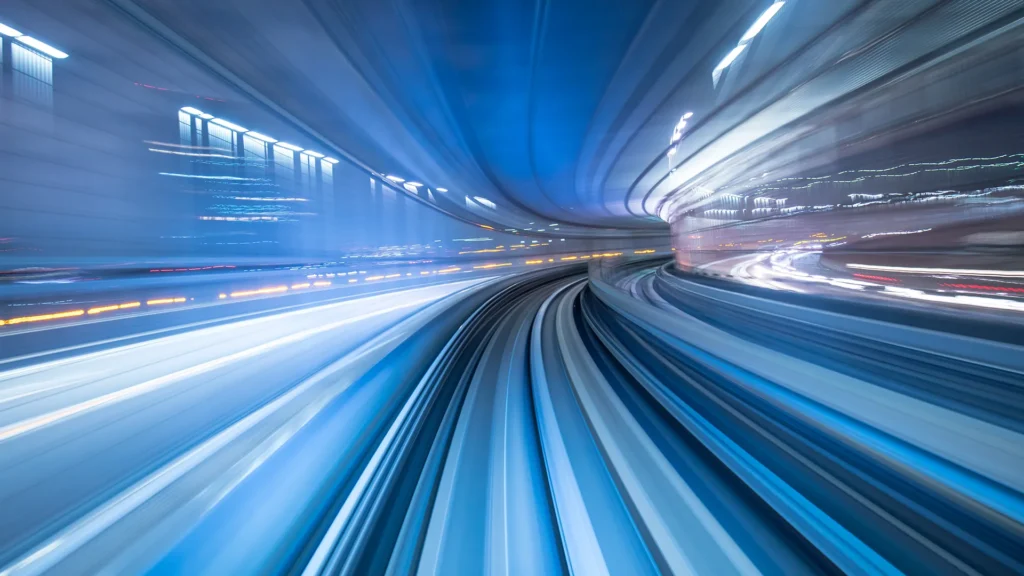 Bilden är tagen med lång slutartid. Vyn är ut genom loket på ett tåg. Det man ser är tunneln tåget kör i i rörelseoskärpa.