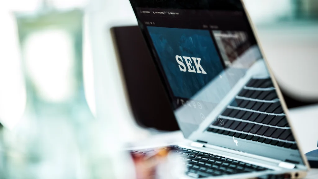 En laptop. På skärmen syns SEK:s logotyp.