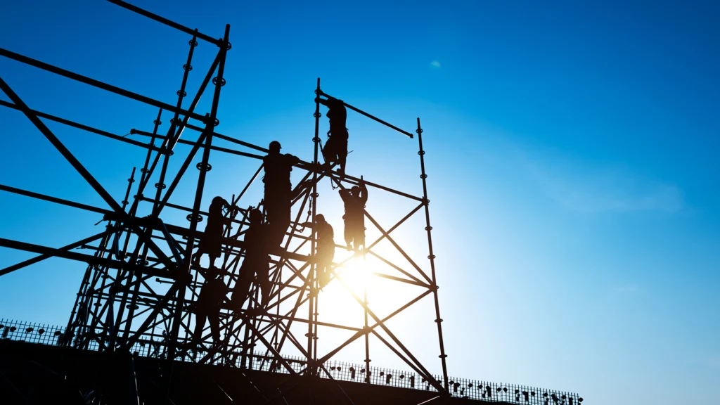 En byggarbetsplats med byggarbetare i motljus.